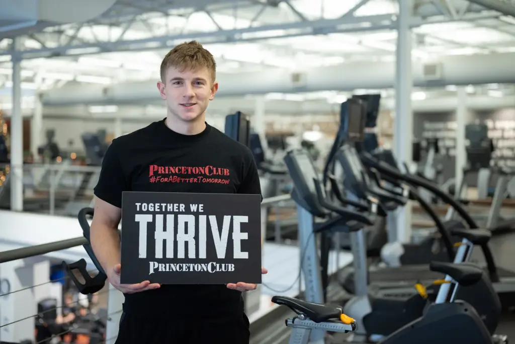 a man holding a sign saying "Together we thrive"